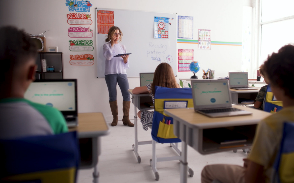 A teacher stands at the front of a class of six-year-old students.