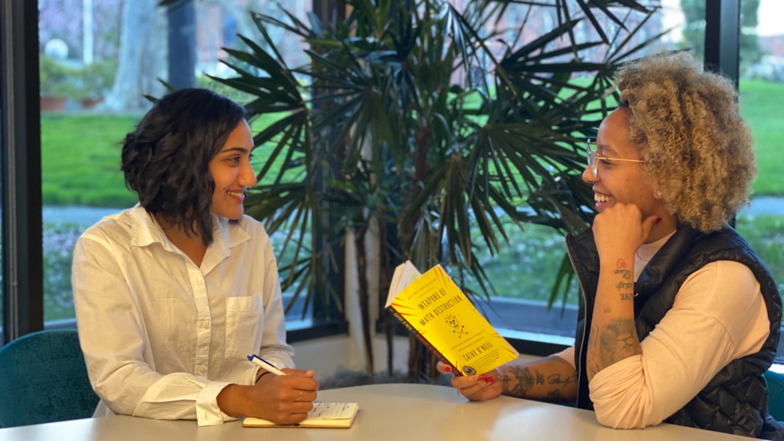 A photo of two women, Madison of Nidhi of the EdTech Equity Project, sitting and talking.