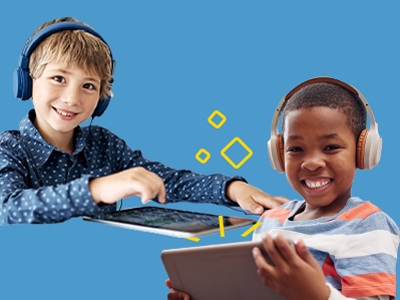 Two young boys are smiling while wearing headphones and using digital tablets.