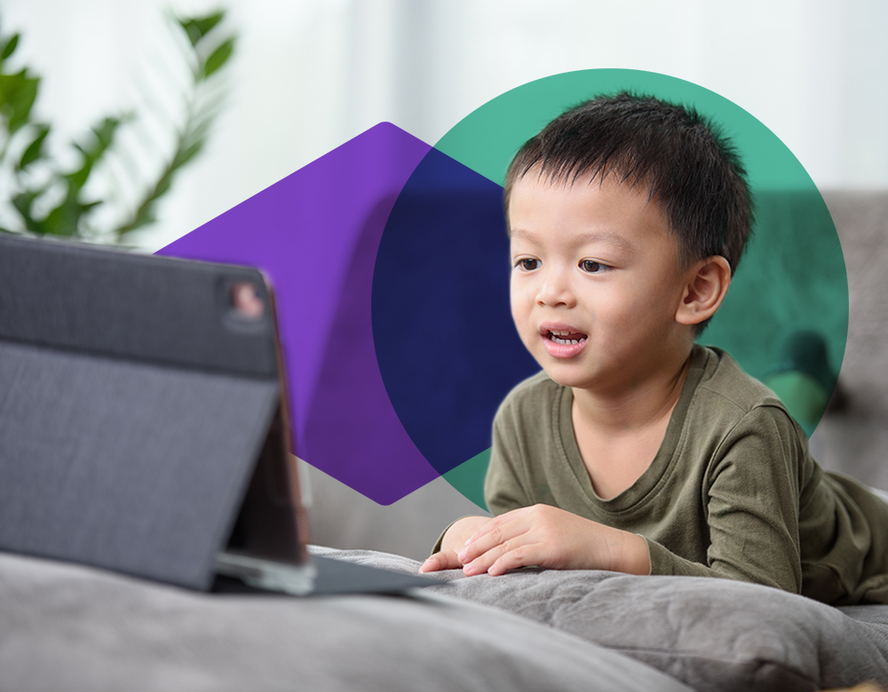 A boy speaking into a tablet computer, voice-enabled with SoapBox's Labs' speech-to-text technology for kids.